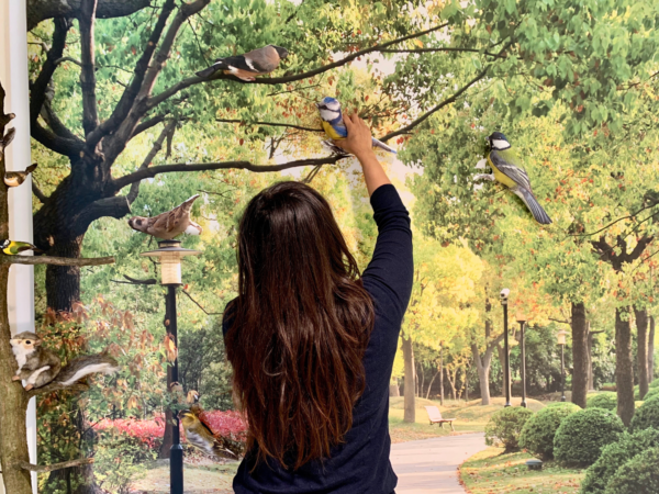 vrouw plakt knuffel vogel op beleefpaneel